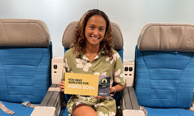 Vahine Fierro Vahine Fierro sur les sièges premium d'Air Tahiti Nui qui tient une pancarte Paris 2024